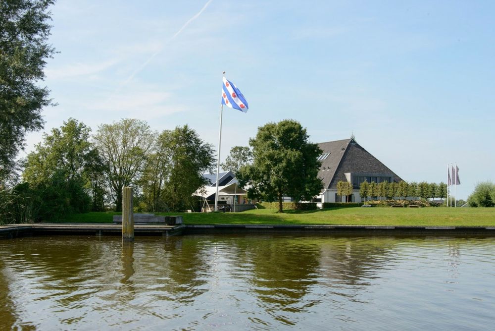 De Pollepleats in Westhem, gezien vanaf het water met de Friese vlag